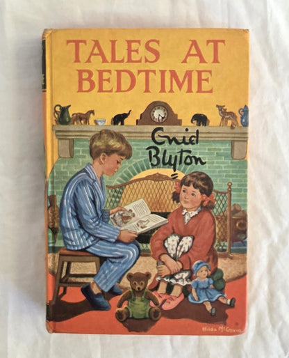 Book cover of 'Tales at Bedtime' by Enid Blyton with illustration of two children and toys.