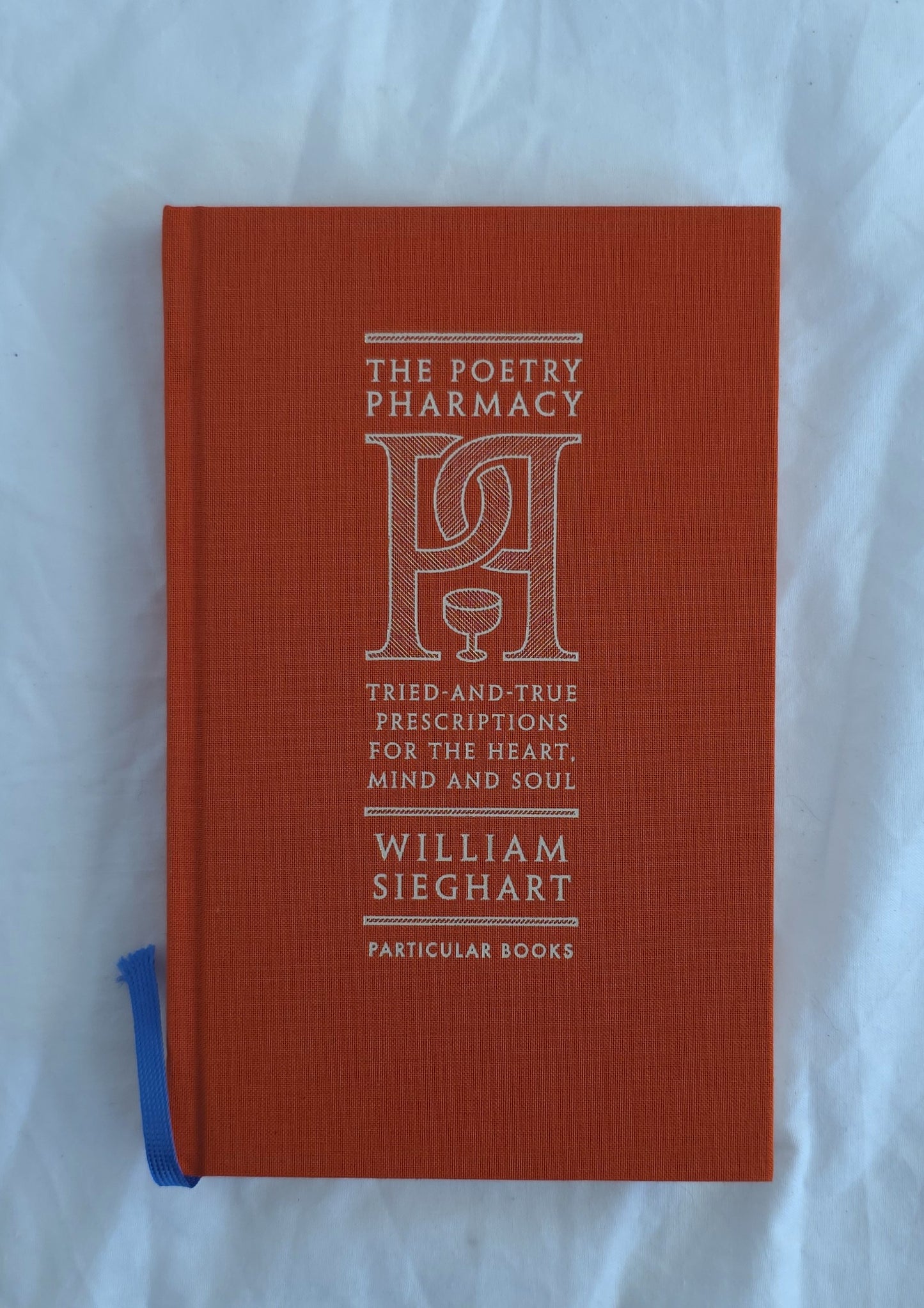 Red book titled 'The Poetry Pharmacy' by William Sieghart on a white background