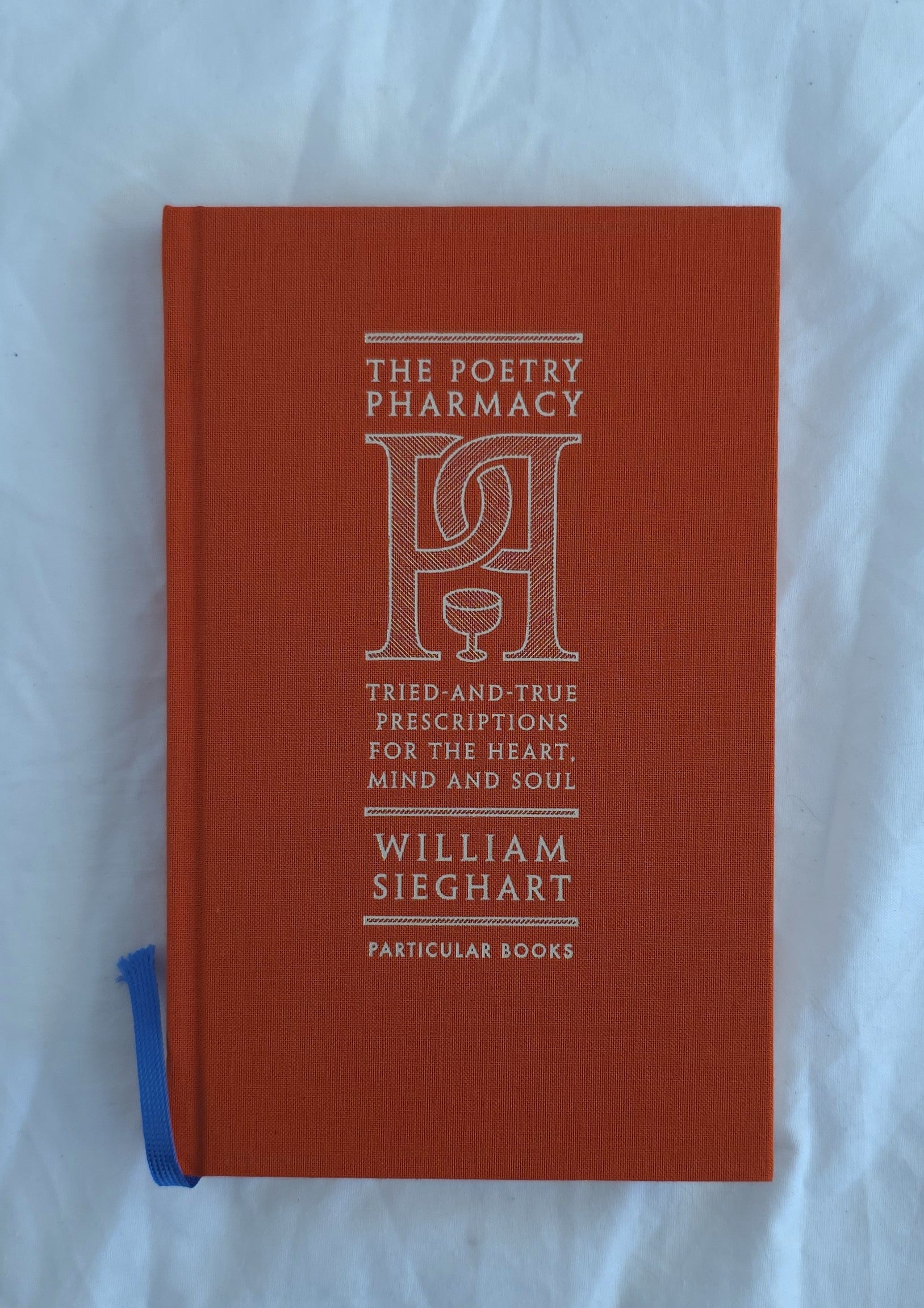 Red book titled 'The Poetry Pharmacy' by William Sieghart on a white background