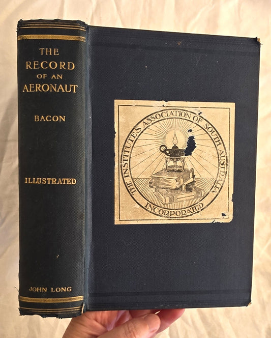 Vintage book titled 'The Record of an Aeronaut' by Bacon held by a person.