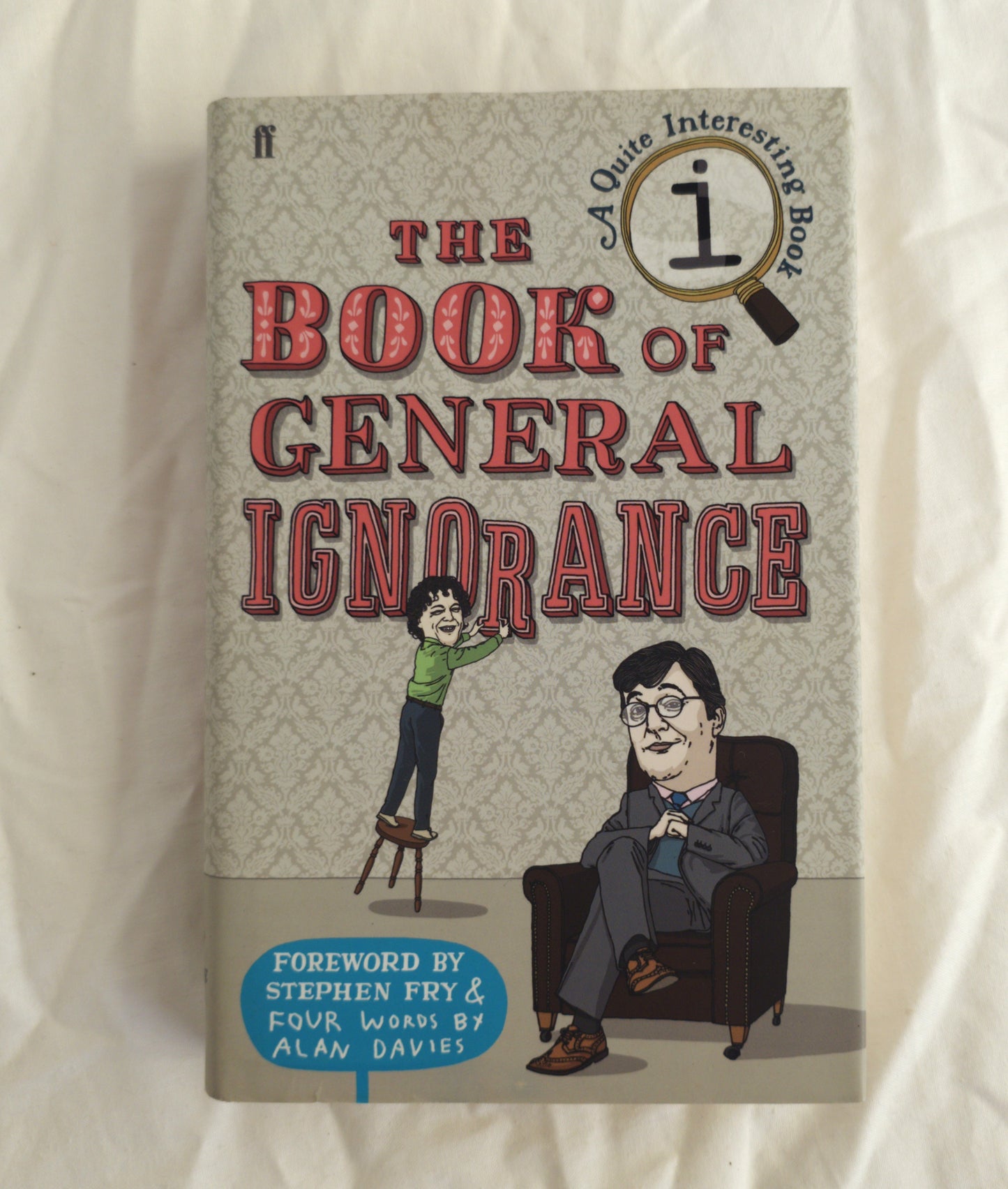 Book cover of 'The Book of General Ignorance' with illustrations of a man and a woman on a white background.