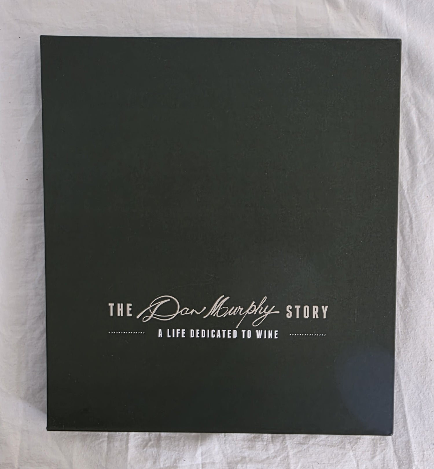 Black box with 'The Dan Murphy Story' text on a textured white background