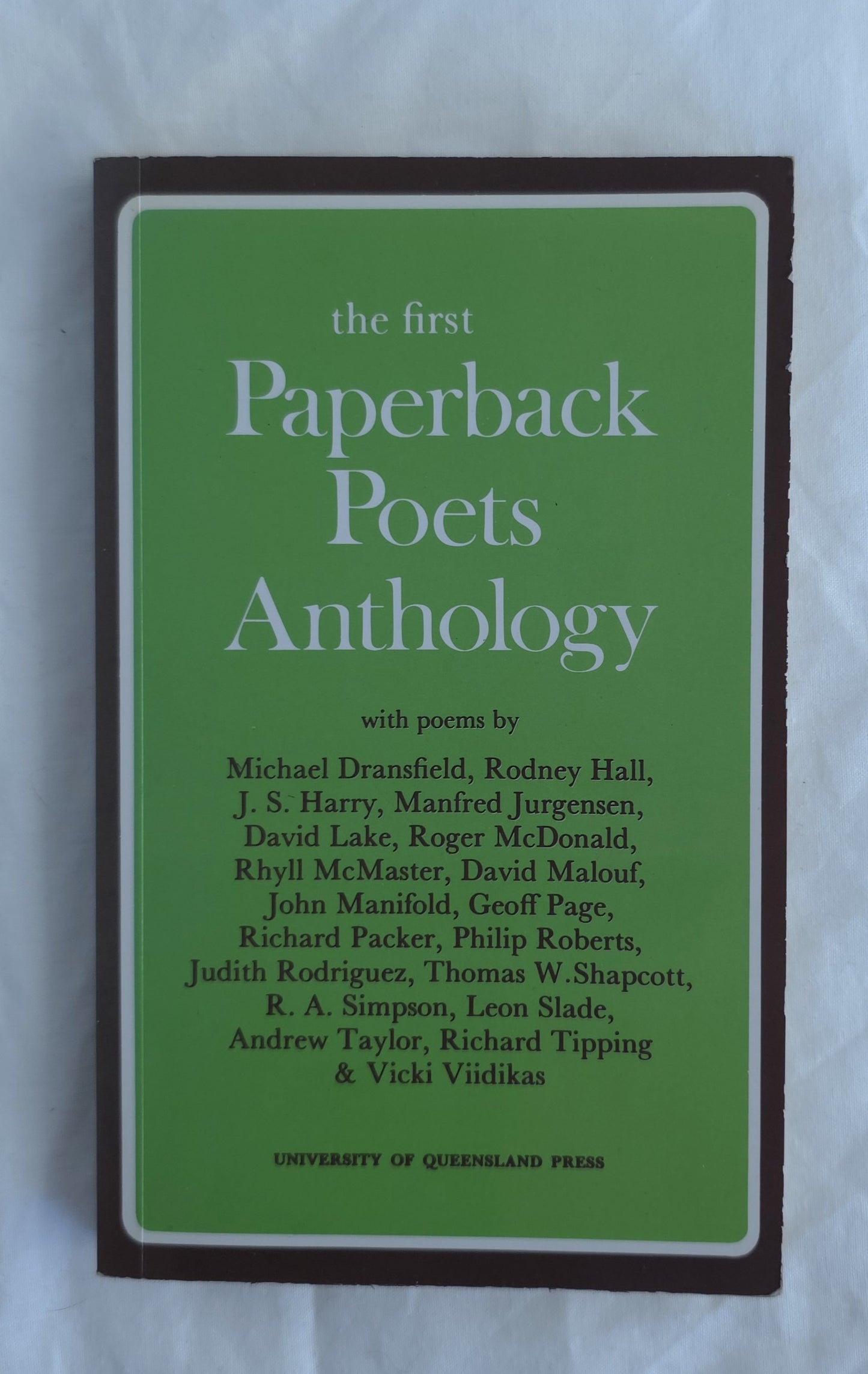 Book cover of 'The First Paperback Poets Anthology' with a green background and brown border.
