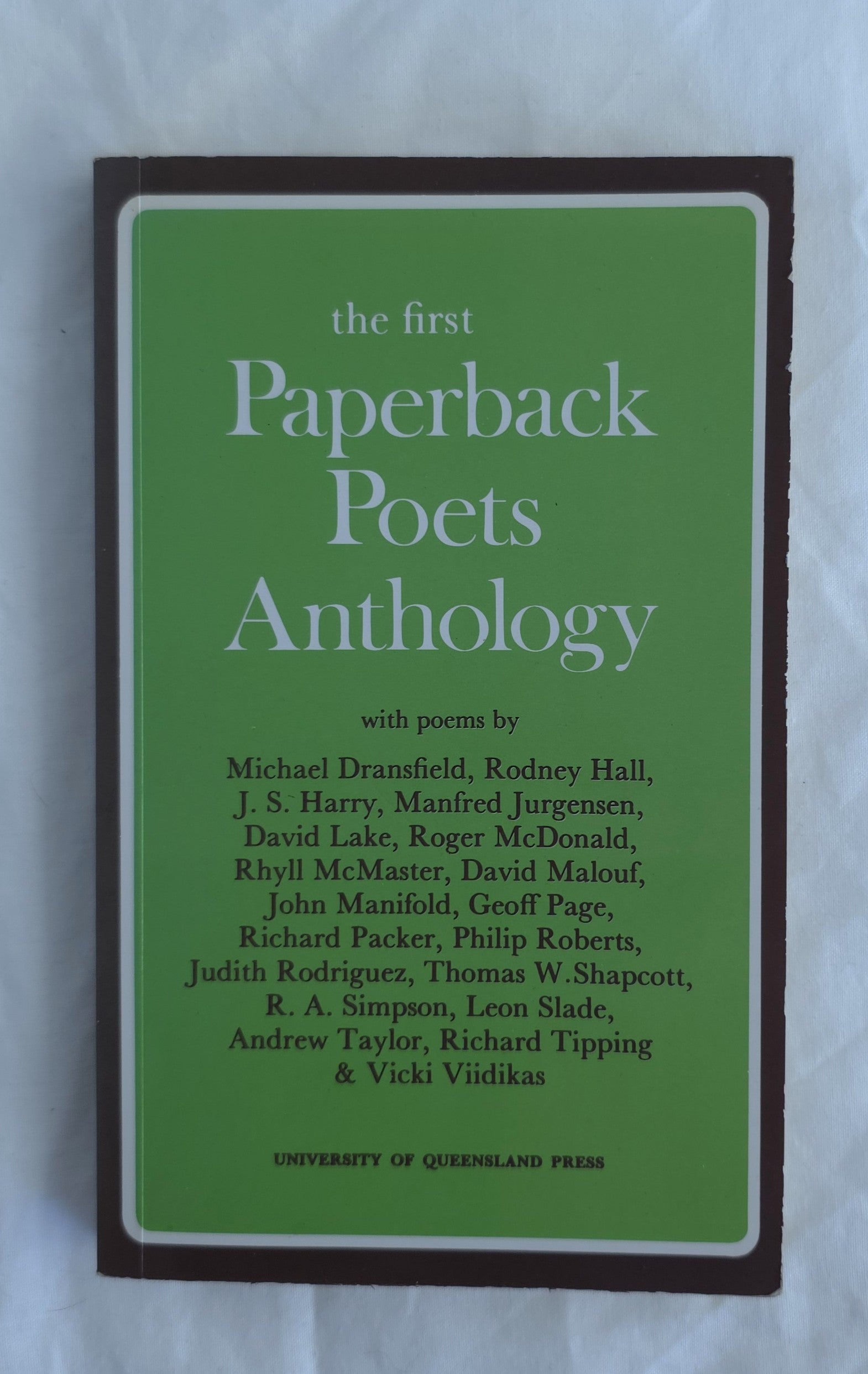 Book cover of 'The First Paperback Poets Anthology' with a green background and brown border.