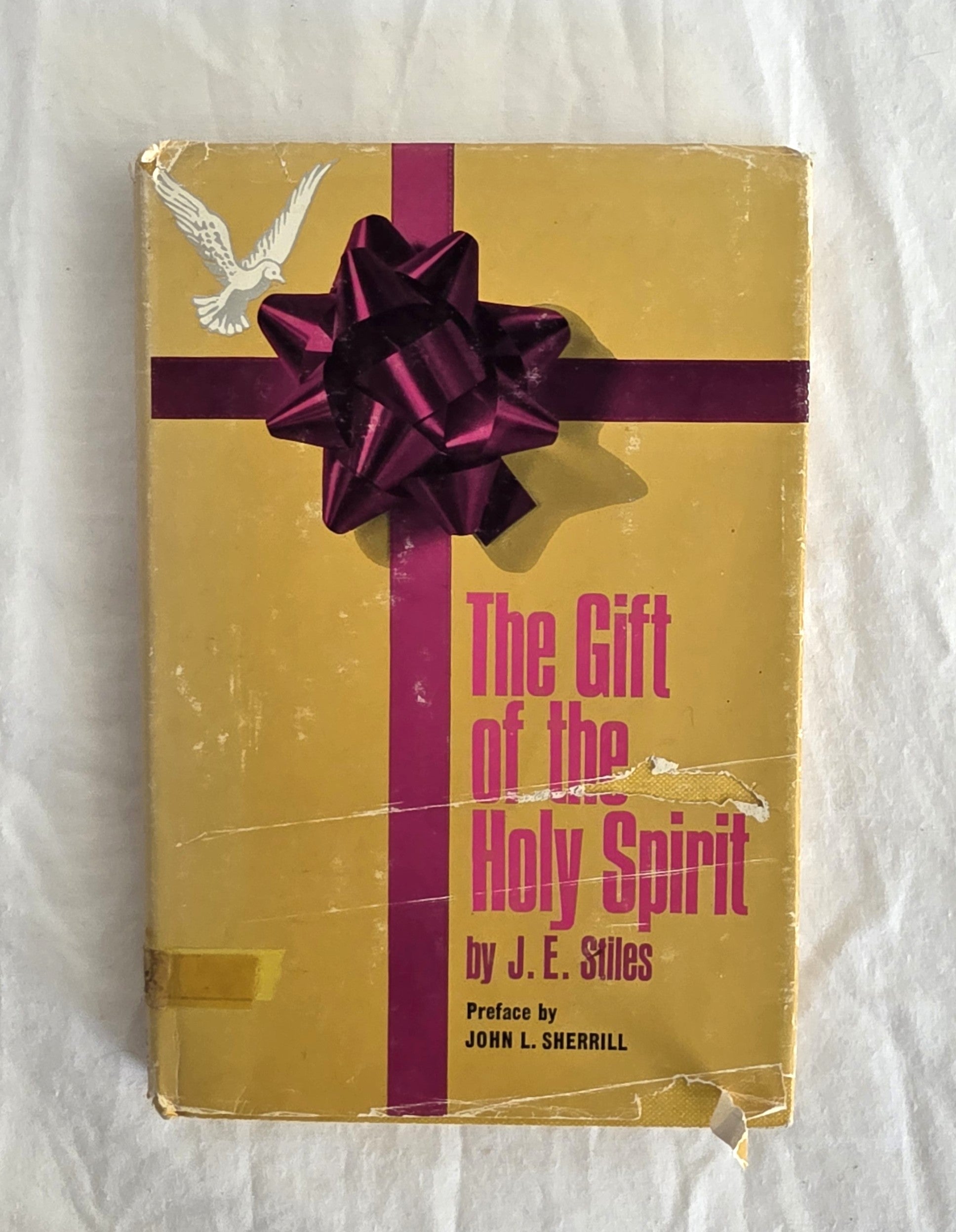 Book titled 'The Gift of the Holy Spirit' with a purple bow on a white background