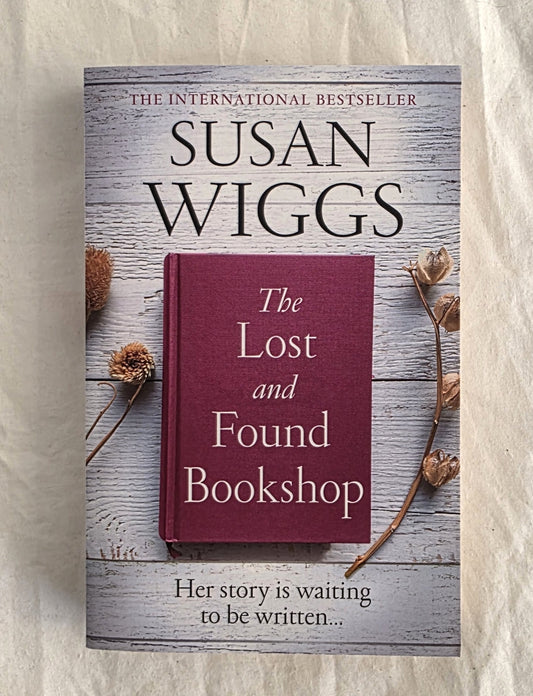 Book cover of 'The Lost and Found Bookshop' by Susan Wiggs on a textured surface.