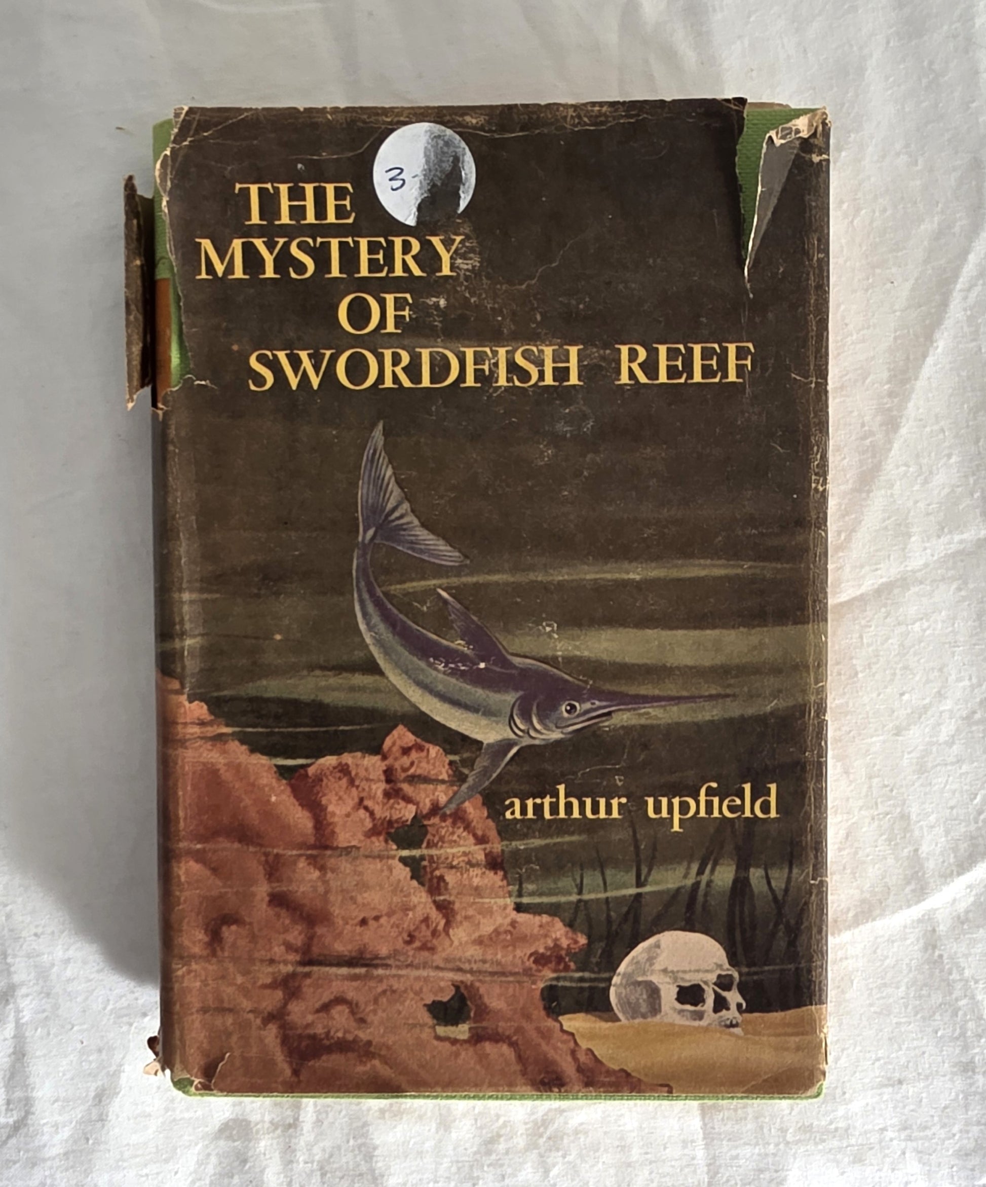 Book titled 'The Mystery of Swordfish Reef' by Arthur Upfield with a swordfish illustration on the cover.