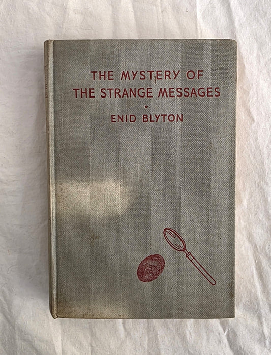Book titled 'The Mystery of the Strange Messages' by Enid Blyton on a textured white background