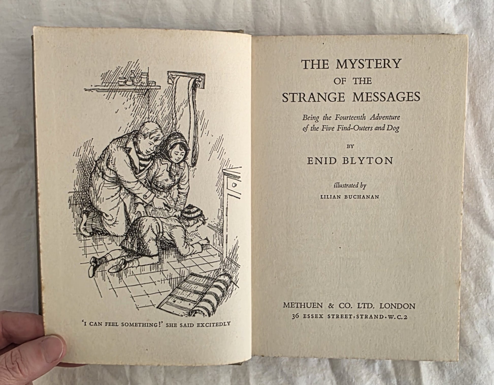 Open book showing the title page of 'The Mystery of the Strange Messages' by Enid Blyton.