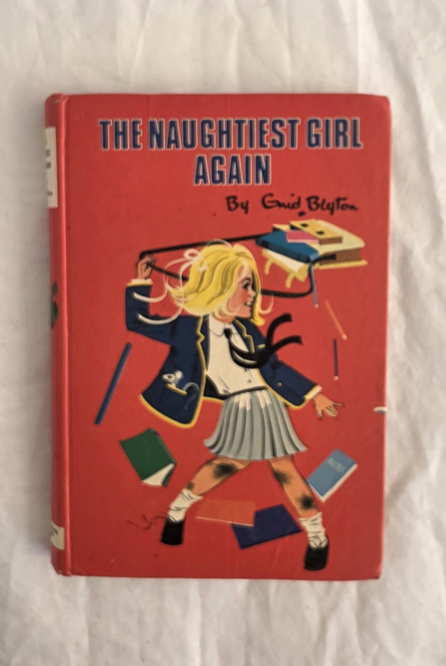 Book cover of 'The Naughtiest Girl Again' by Enid Blyton on a white background