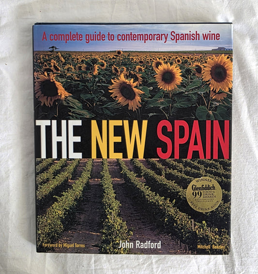 Book cover of 'The New Spain' by John Radford with sunflower field and vineyard design.