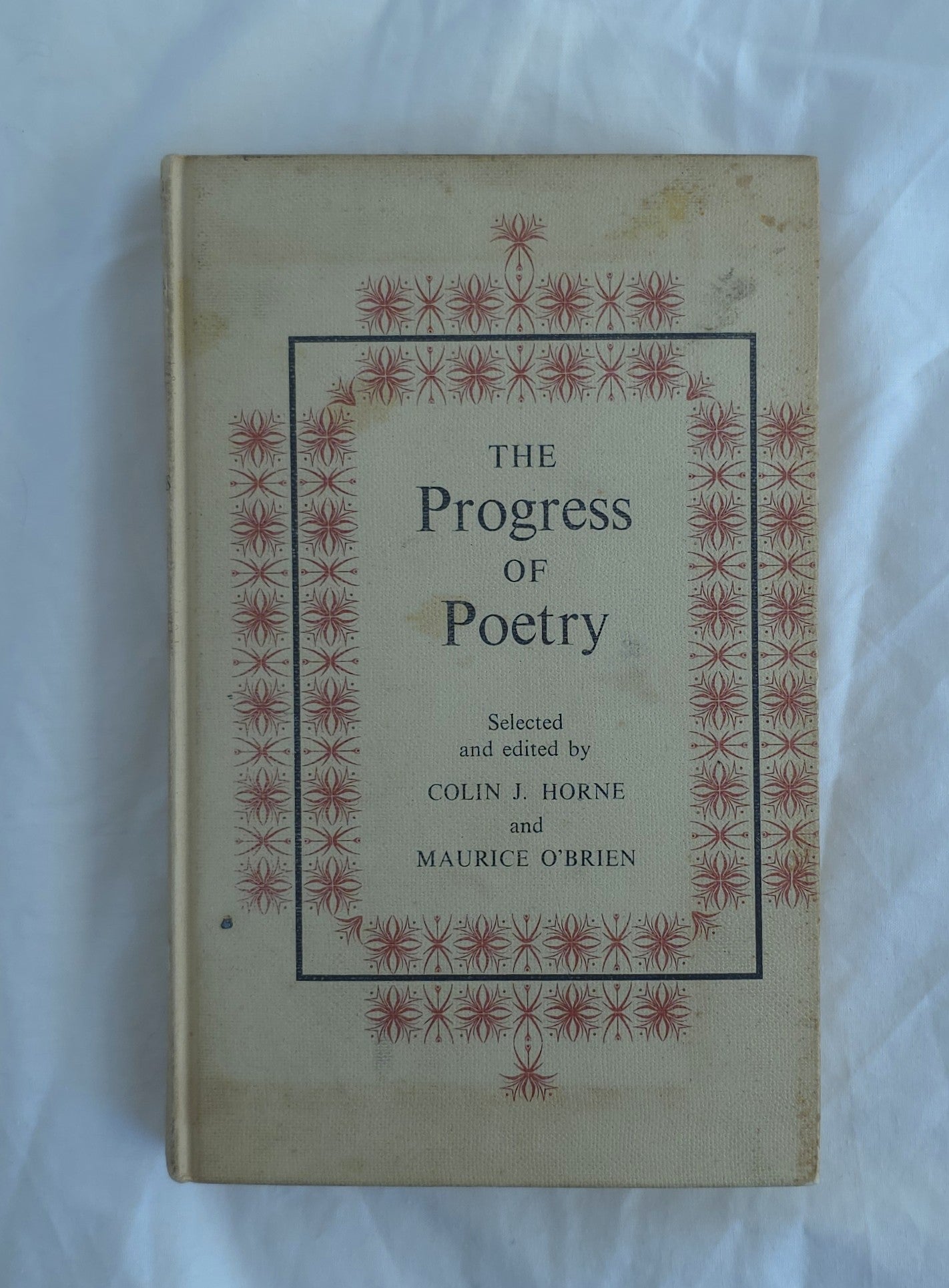 Book titled 'The Progress of Poetry' with decorative cover on a white background