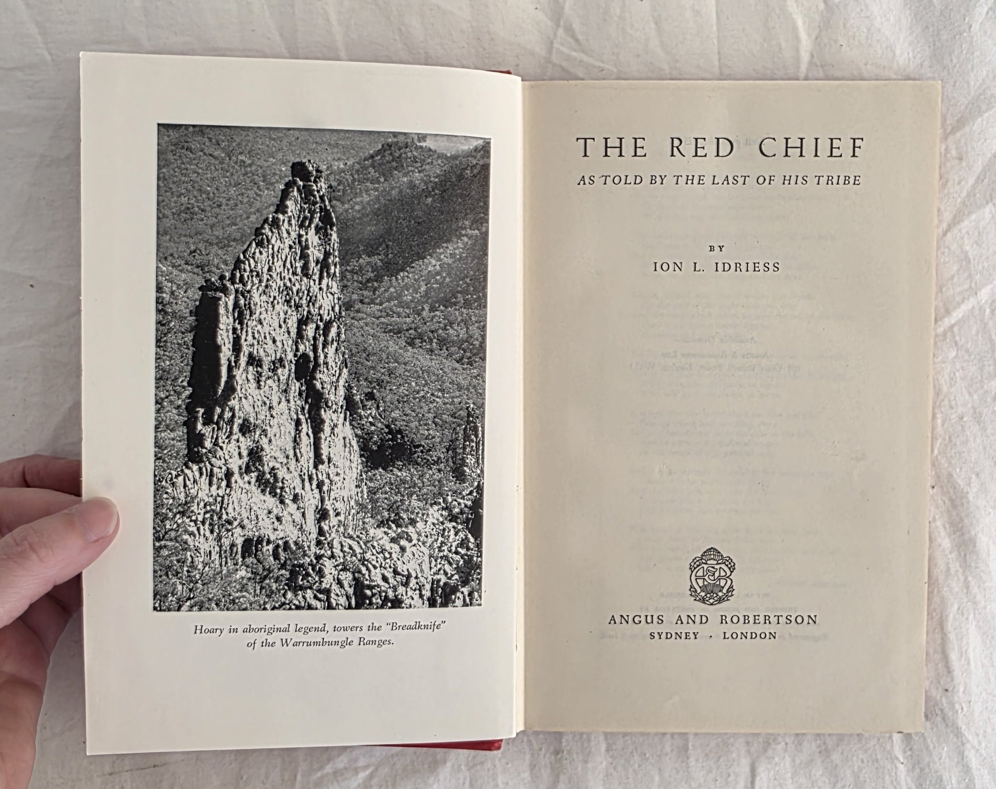 Open book titled 'The Red Chief' with a black and white photograph on the left page.