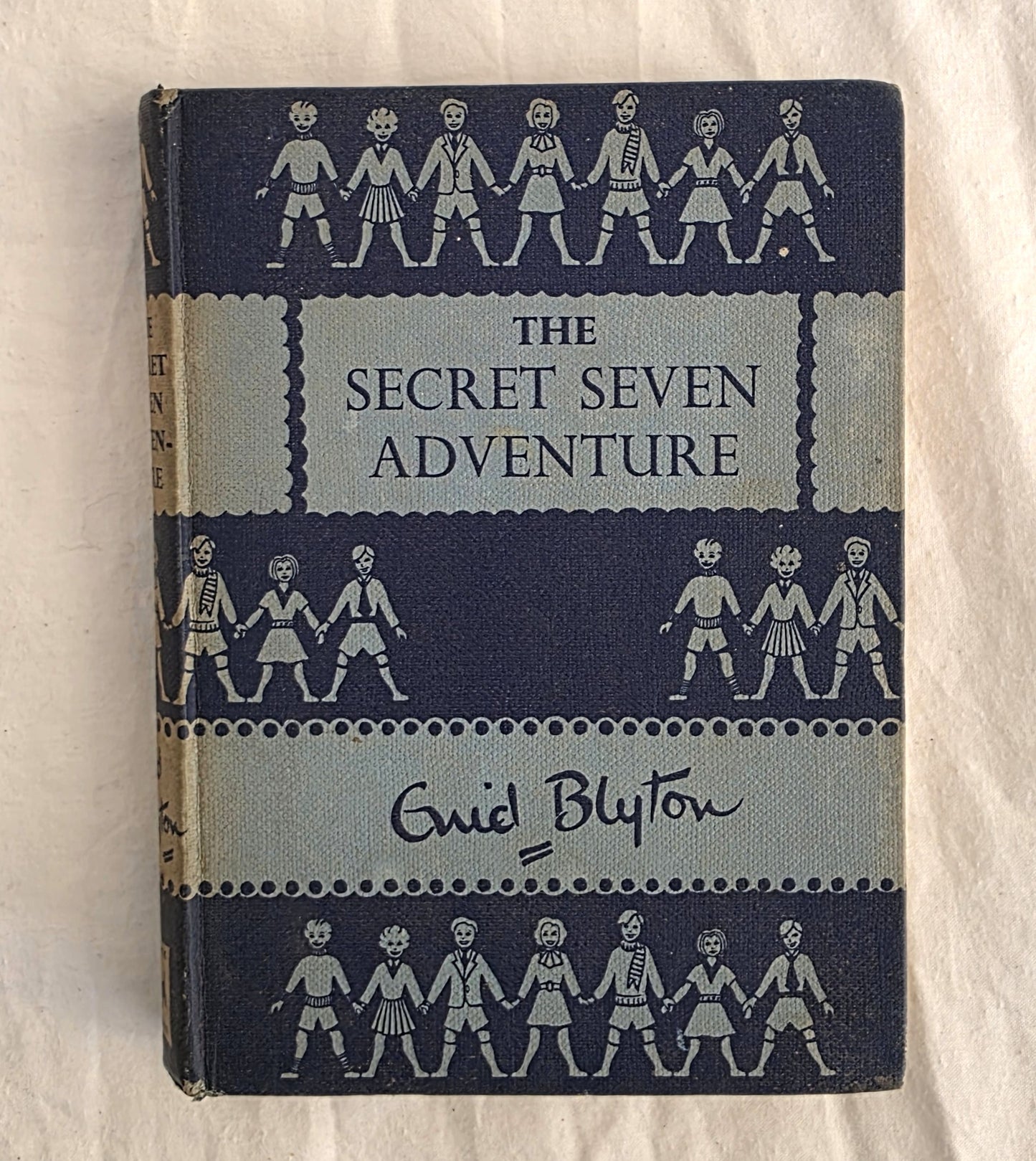 Book titled 'The Secret Seven Adventure' by Enid Blyton on a white background