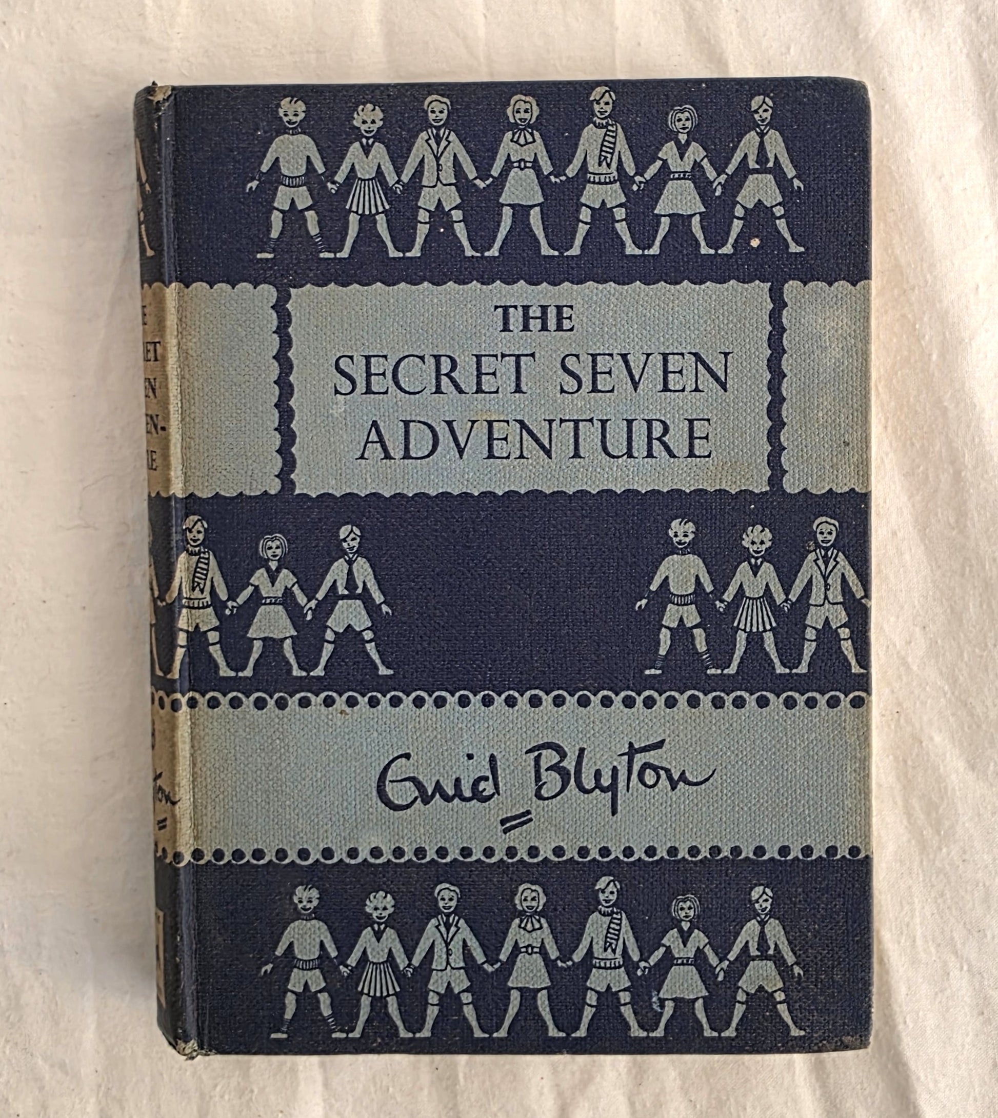 Book titled 'The Secret Seven Adventure' by Enid Blyton on a white background