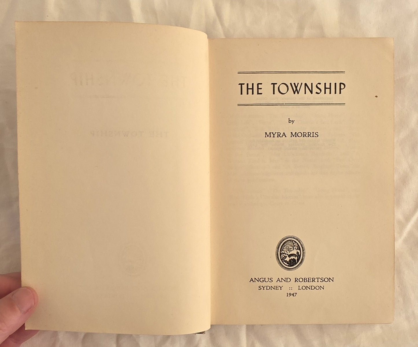 Open book titled 'The Township' by Myra Morris with a visible publisher's logo.