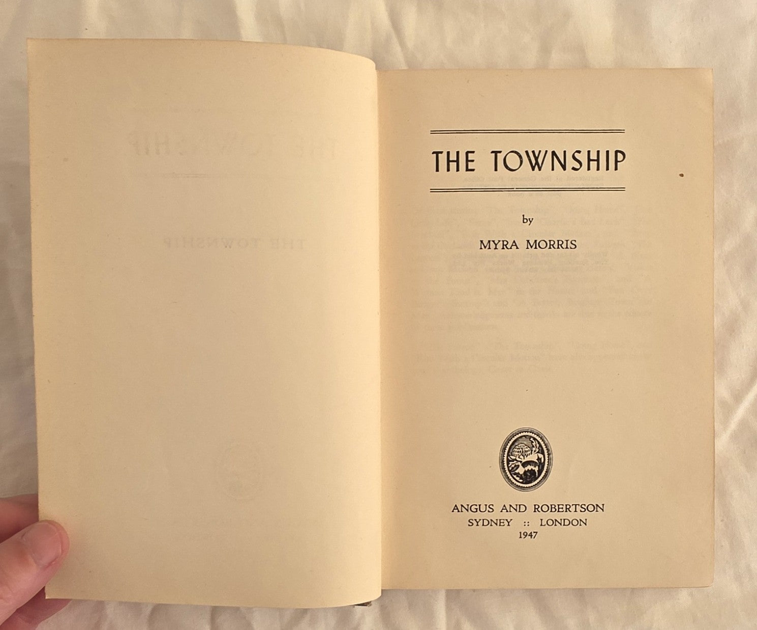 Open book titled 'The Township' by Myra Morris with a visible publisher's logo.