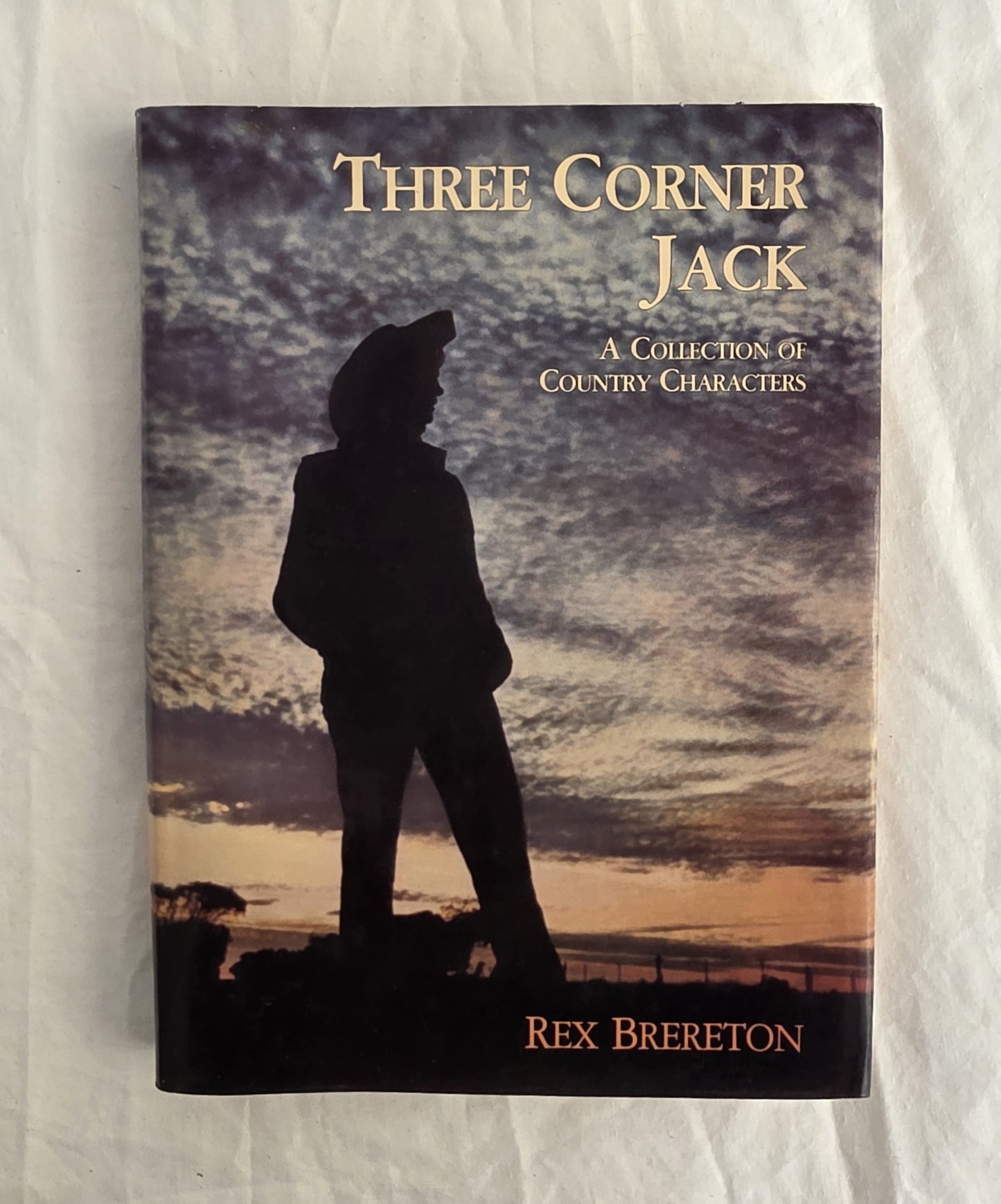 Book cover of 'Three Corner Jack' by Rex Brereton with a silhouette against a sunset sky.