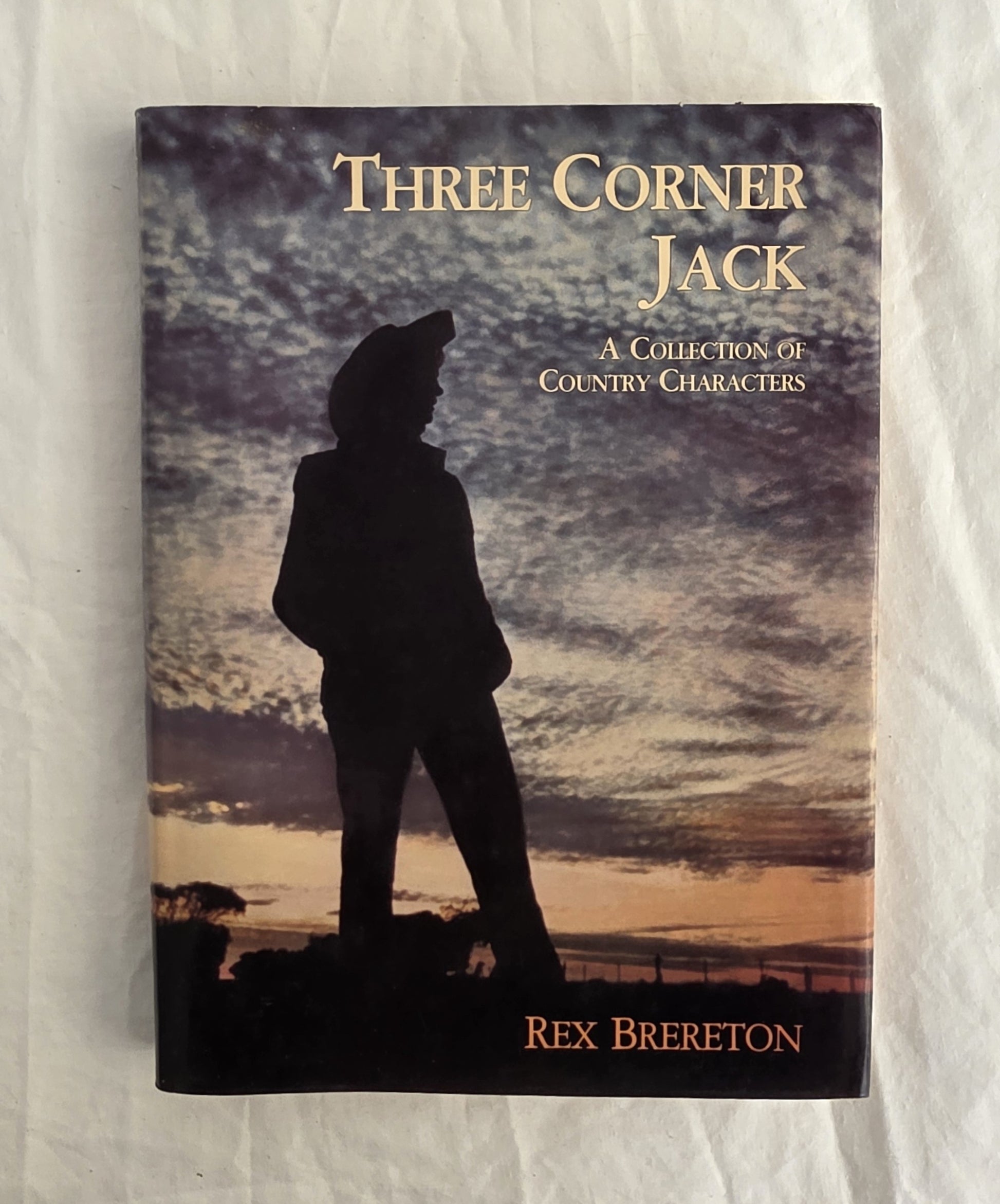Book cover of 'Three Corner Jack' by Rex Brereton with a silhouette against a sunset sky.