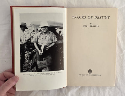 Open book titled 'Tracks of Destiny' by Ion L. Idriess, held against a white background.