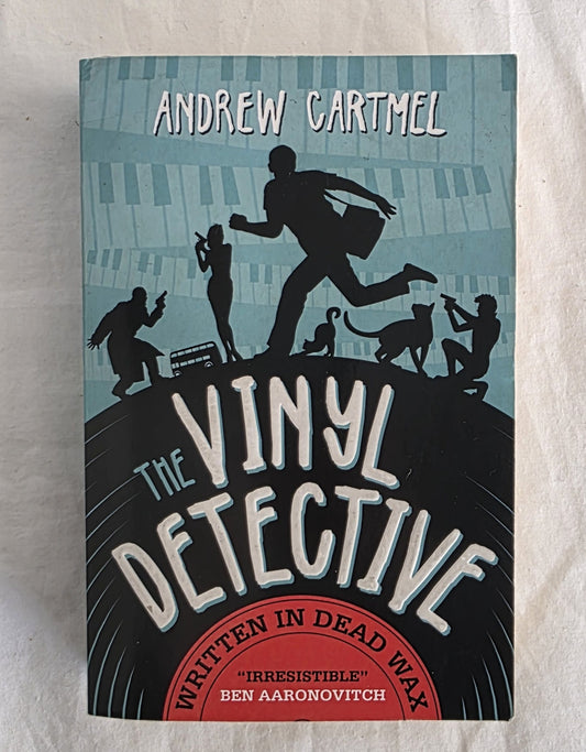 Book cover of 'The Vinyl Detective' by Andrew Cartmel on a textured surface