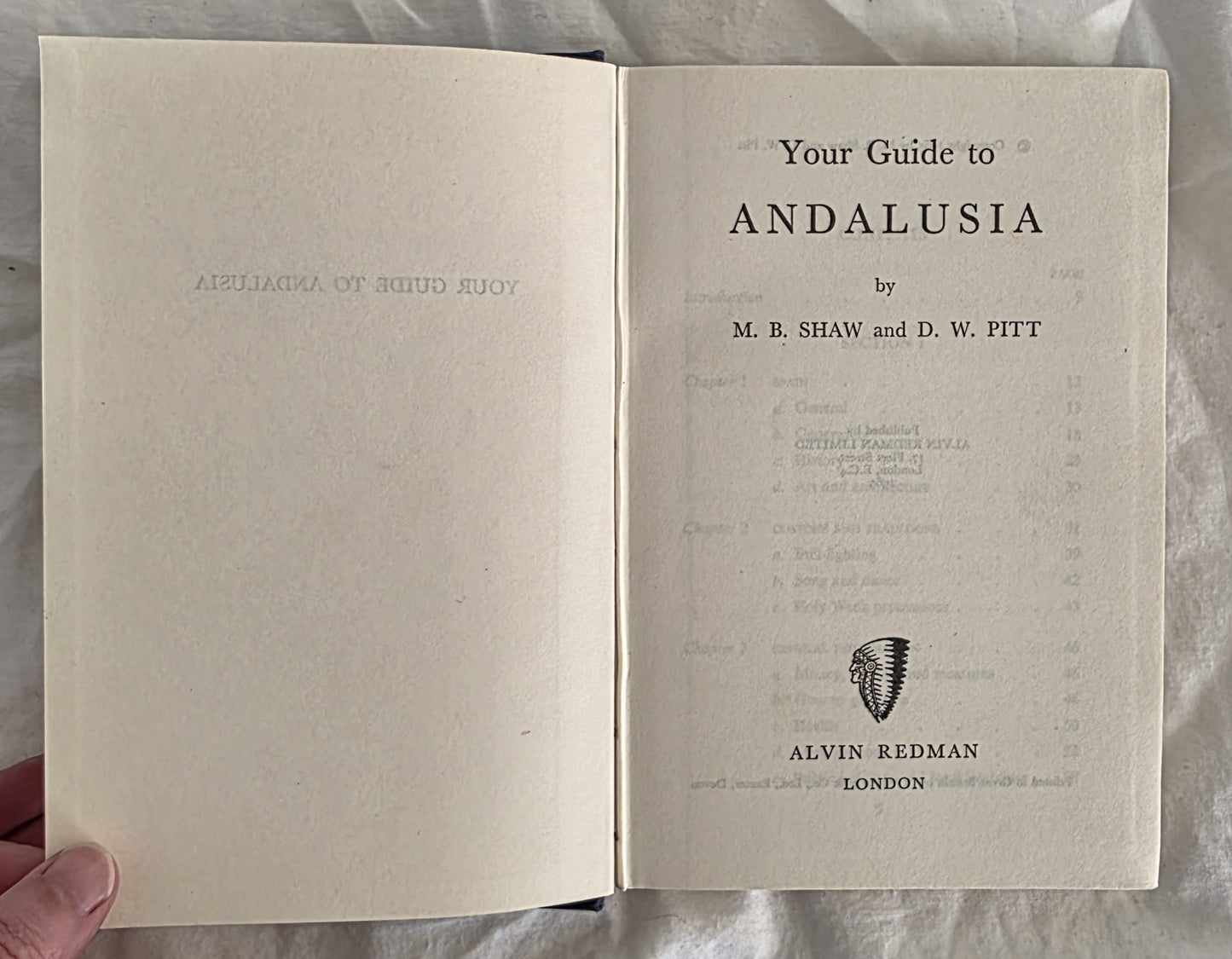Open book titled 'Your Guide to Andalusia' by M.B. Shaw and D.W. Pitt, held against a neutral background.