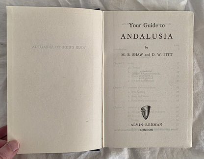 Open book titled 'Your Guide to Andalusia' by M.B. Shaw and D.W. Pitt, held against a neutral background.
